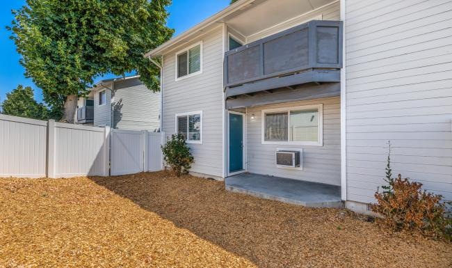 a house with a fence and a tree in the front